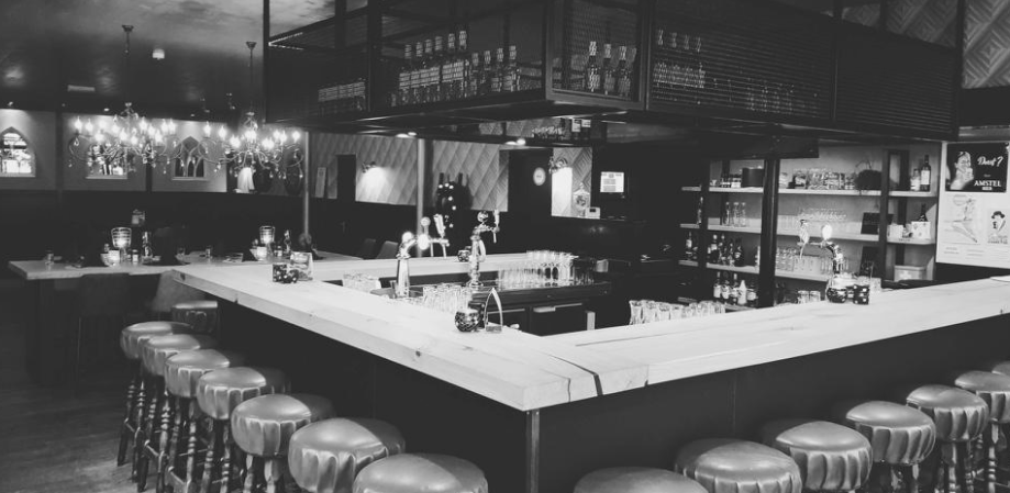 Binnen bij Bar De Borrel met een bar met barkrukken